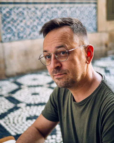 Elias Varga, CryptoReel's editor, at a cafe table in Lisbon